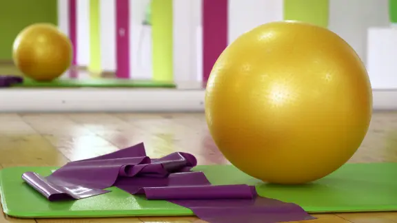 Exercise ball and resistance band on a mat in a clinical Pilates studio